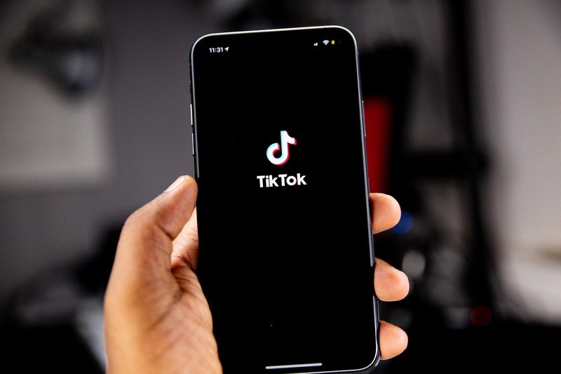 A person holding an iPhone running TikTok